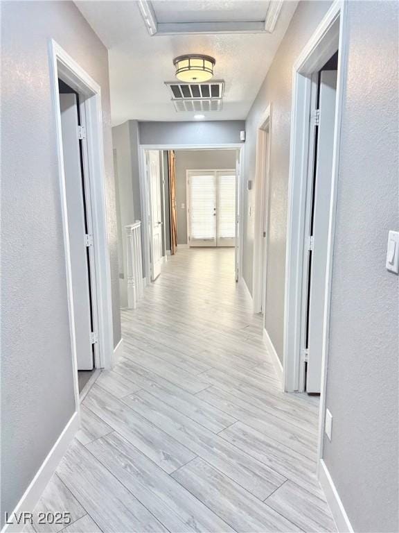 corridor with light hardwood / wood-style floors