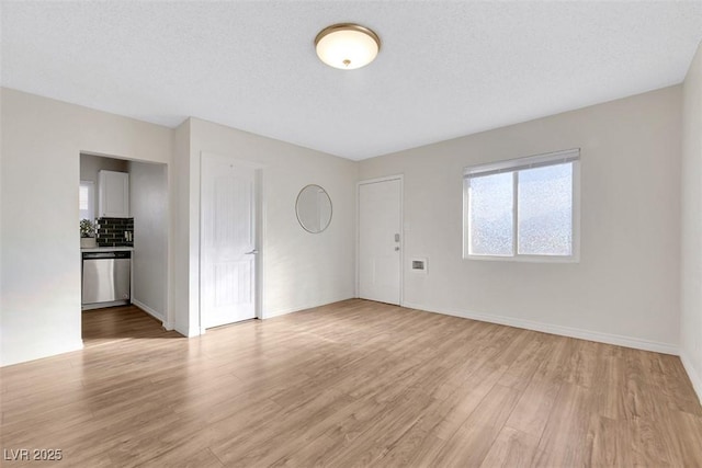 unfurnished living room featuring a textured ceiling and light wood-type flooring