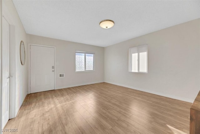 empty room featuring a textured ceiling and light wood-type flooring