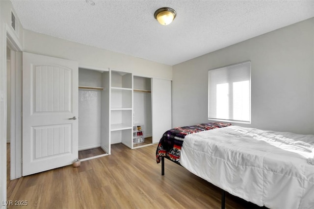 bedroom featuring wood-type flooring and a textured ceiling