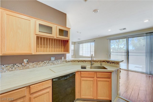 kitchen with black dishwasher, sink, light brown cabinets, and kitchen peninsula