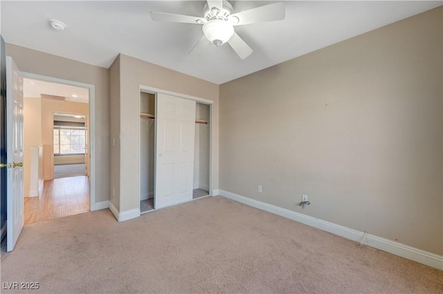 unfurnished bedroom featuring light carpet, a closet, and ceiling fan