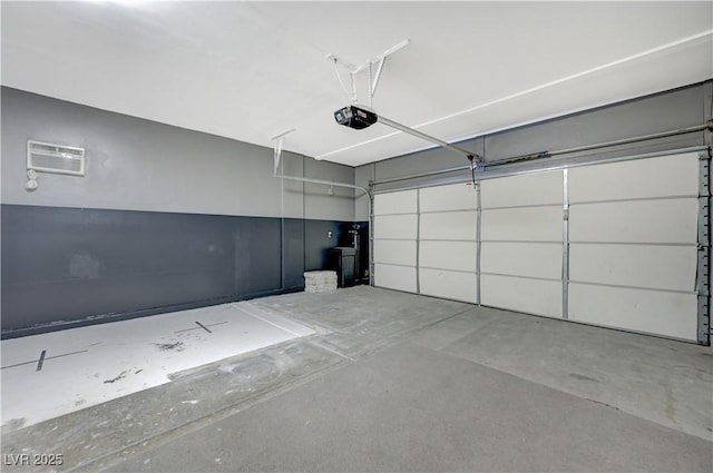 garage with a garage door opener and an AC wall unit