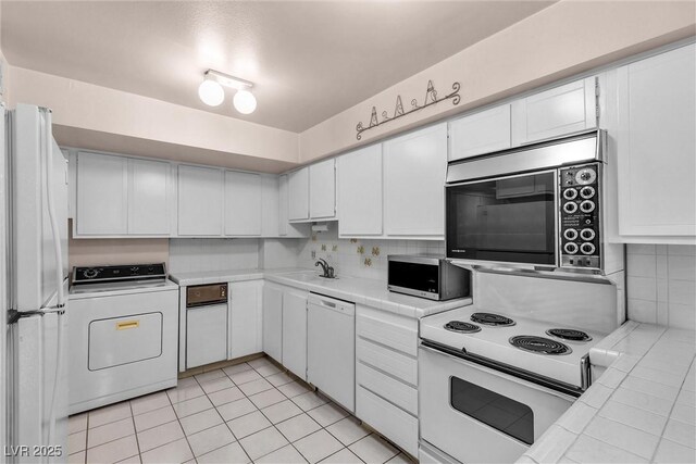 kitchen featuring washer / clothes dryer, white cabinetry, tasteful backsplash, and white appliances