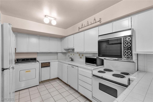 kitchen with white cabinetry, white appliances, washer / dryer, and decorative backsplash