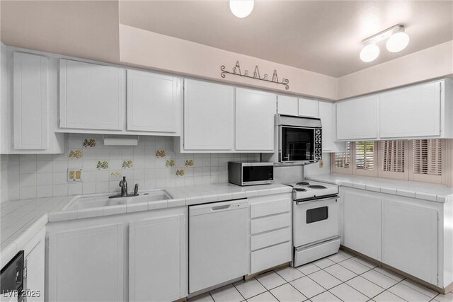 kitchen with white cabinetry, white appliances, tile countertops, and tasteful backsplash