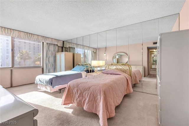 bedroom featuring light colored carpet and a textured ceiling