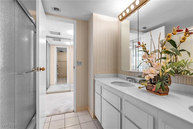 bathroom with tile patterned floors, toilet, a textured ceiling, and vanity