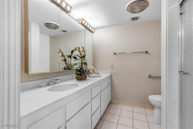 bathroom with tile patterned floors, toilet, vanity, and a textured ceiling