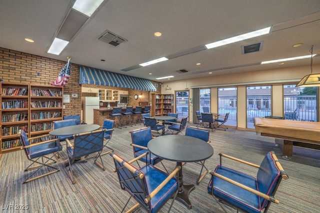 interior space with brick wall, carpet floors, and pool table