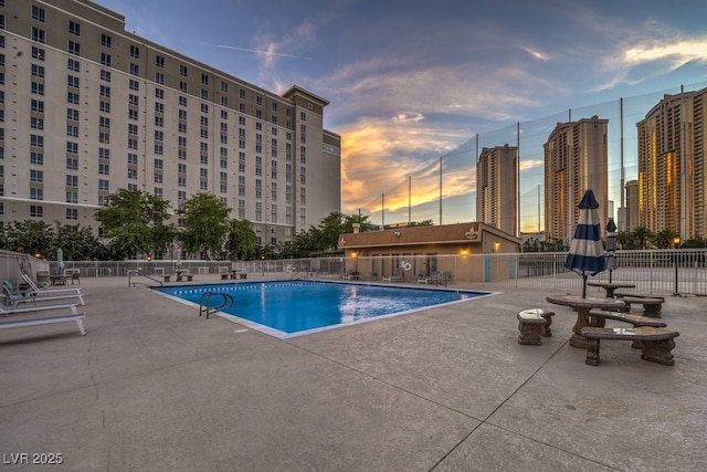 pool at dusk with a patio area