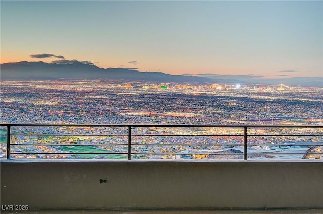 balcony at dusk featuring a mountain view