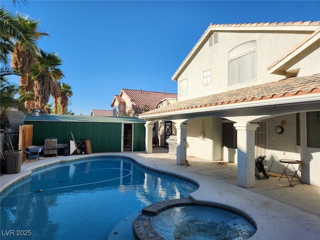 view of pool with an in ground hot tub and a patio