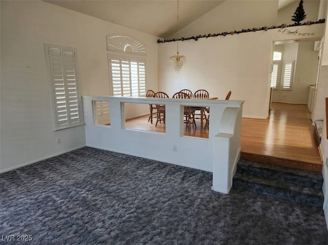 unfurnished dining area featuring dark colored carpet, lofted ceiling, and a notable chandelier