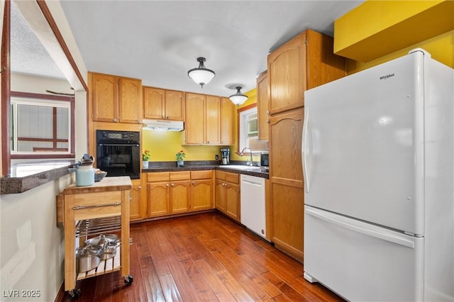 kitchen featuring sink, dark wood-type flooring, and white appliances