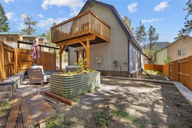 back of house with a deck and a patio area