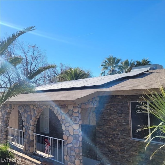 view of side of property featuring solar panels