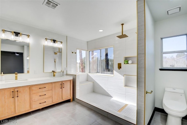 bathroom with vanity, toilet, tile patterned flooring, and walk in shower