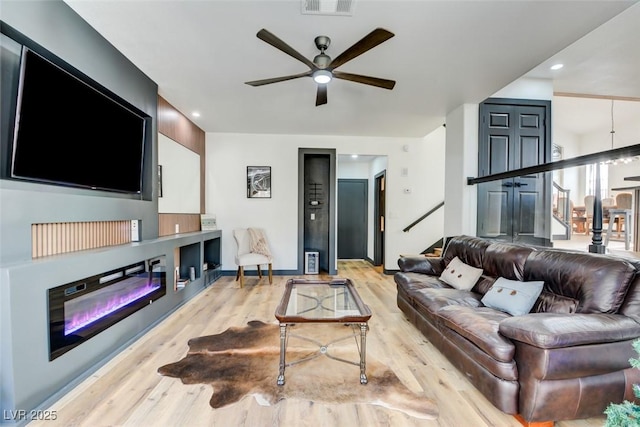 living room featuring ceiling fan and light hardwood / wood-style flooring