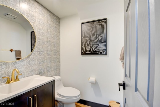 bathroom featuring vanity, toilet, and decorative backsplash