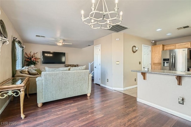 living room featuring dark hardwood / wood-style flooring and ceiling fan with notable chandelier