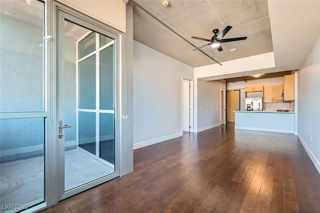 unfurnished living room with dark hardwood / wood-style flooring and ceiling fan