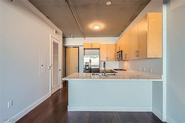 kitchen with light brown cabinets, sink, dark hardwood / wood-style floors, appliances with stainless steel finishes, and kitchen peninsula