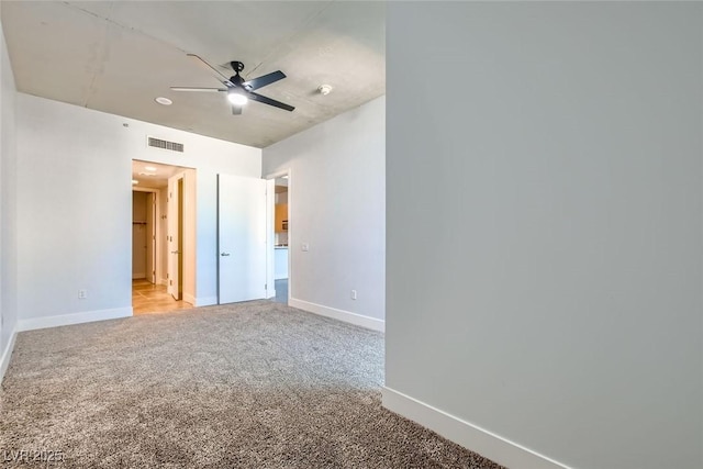 interior space featuring ceiling fan and light colored carpet