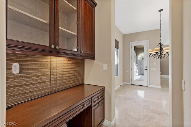 interior space with a chandelier and baseboards