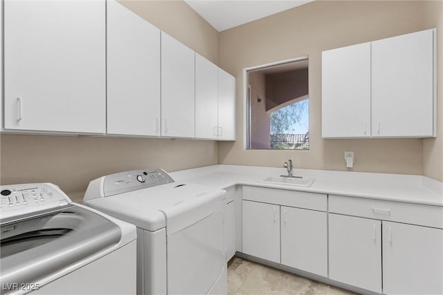 clothes washing area featuring washer and dryer, cabinet space, and a sink