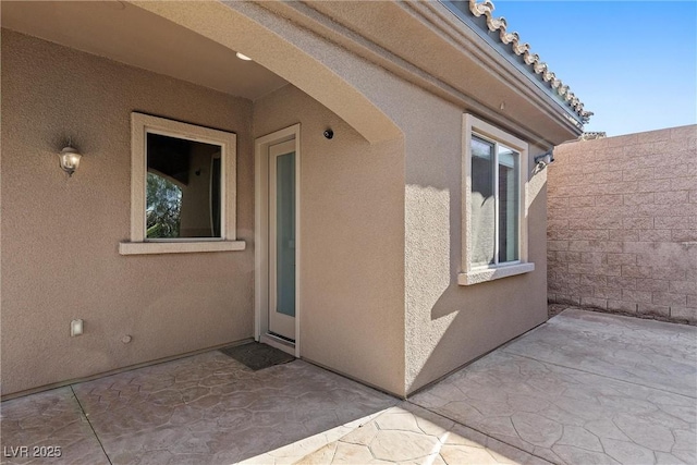 property entrance featuring a patio area and stucco siding