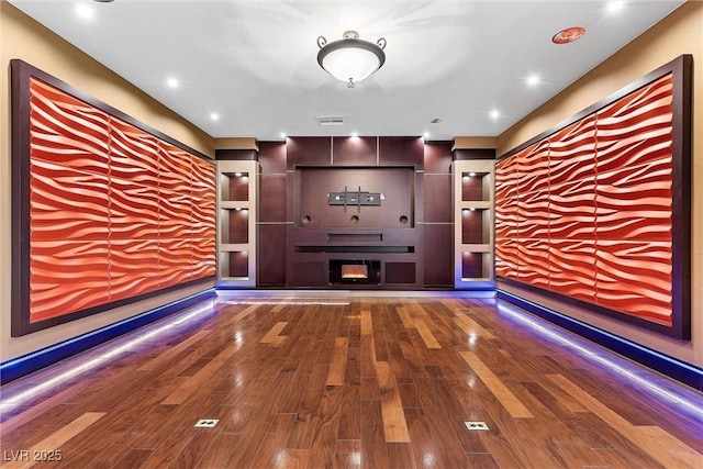 interior space with a fireplace, visible vents, wood finished floors, and recessed lighting