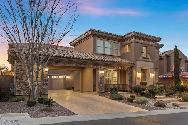 mediterranean / spanish home featuring an attached garage, covered porch, concrete driveway, stone siding, and a tiled roof