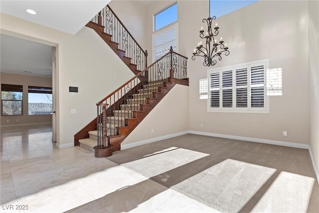 interior space with recessed lighting, baseboards, a high ceiling, and an inviting chandelier