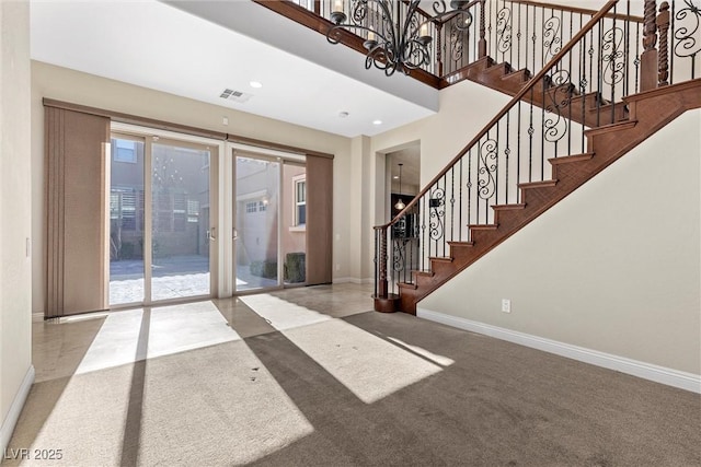 carpeted entrance foyer featuring recessed lighting, visible vents, a towering ceiling, stairway, and baseboards