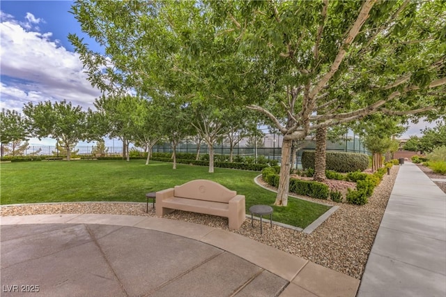 view of community featuring fence, a patio, and a yard