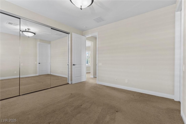 unfurnished bedroom with carpet floors, baseboards, visible vents, and a closet