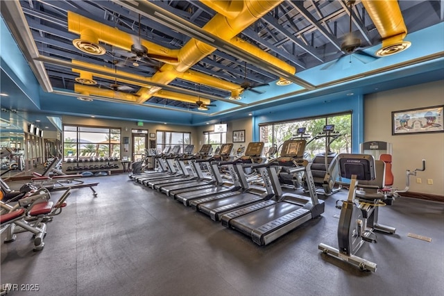 gym featuring a ceiling fan and baseboards