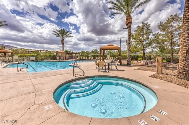 community pool featuring fence, a community hot tub, a patio, and a gazebo