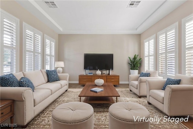 living room featuring baseboards and visible vents