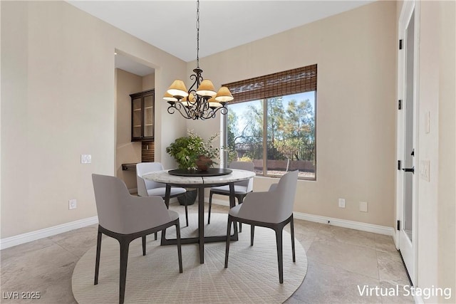 dining space with baseboards and a chandelier