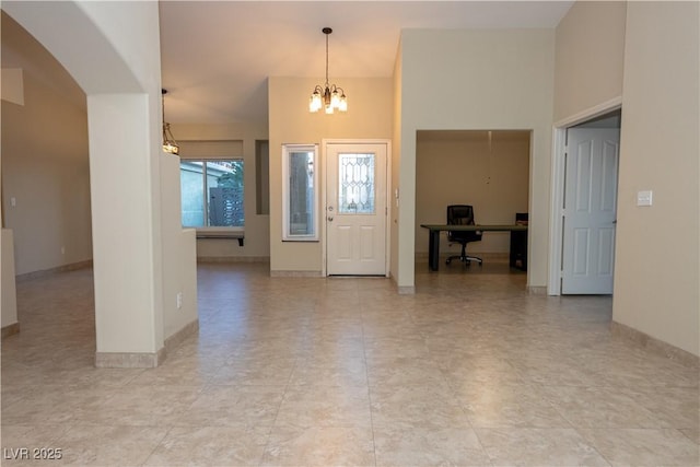 entryway with a high ceiling and a chandelier