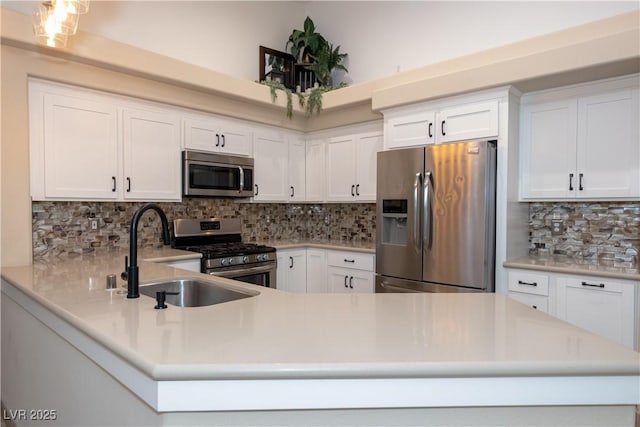 kitchen featuring sink, stainless steel appliances, white cabinetry, and decorative backsplash