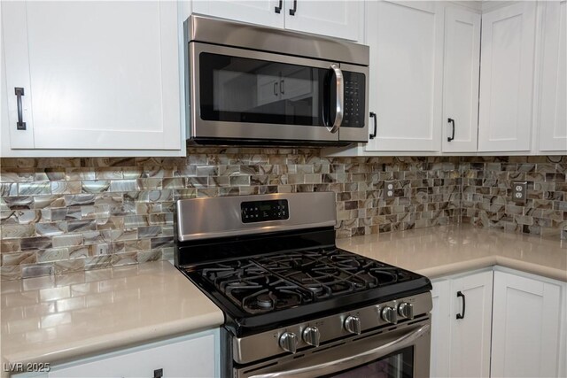 kitchen with white cabinets, stainless steel appliances, and tasteful backsplash