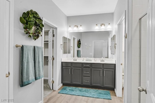 bathroom featuring a shower with door, wood-type flooring, vanity, and toilet