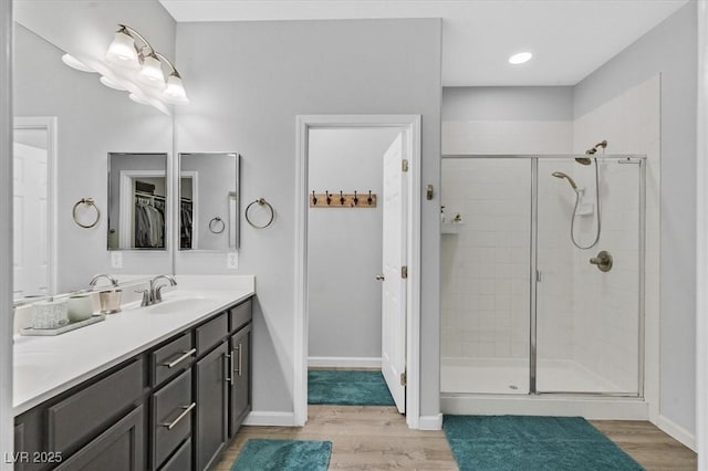 bathroom featuring hardwood / wood-style flooring, vanity, and an enclosed shower