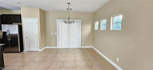 unfurnished dining area featuring light tile patterned floors and an inviting chandelier