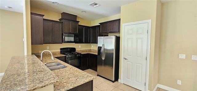 kitchen featuring kitchen peninsula, light stone counters, sink, black appliances, and light tile patterned floors