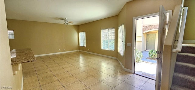 tiled spare room with ceiling fan