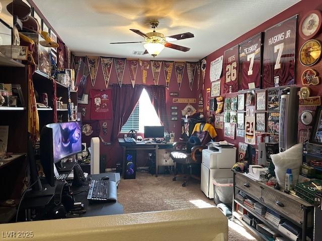 carpeted office space with ceiling fan